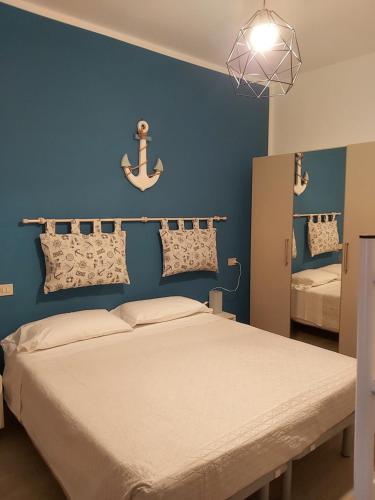 ein Schlafzimmer mit einem Bett und einer blauen Wand in der Unterkunft Hotel 21 Riccione in Riccione