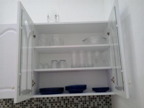 a cabinet filled with glasses and bowls on shelves at Julia Apartment in Budapest