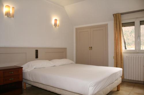 a bedroom with a large white bed and a window at HMC K-ena in Andorra la Vella