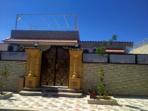 a building with a large wooden gate with a brick wall at قرية رمسيس الكيلو45 الساحل الشمالي in Borg El Arab