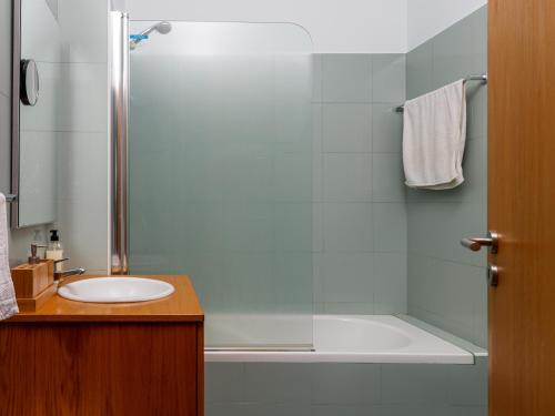 a bathroom with a tub and a sink and a shower at Anthero Quental Boutique Apartment in Ponta Delgada