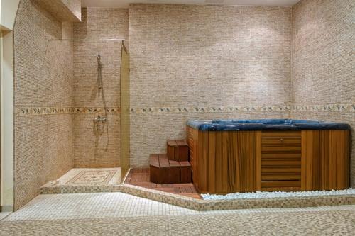 a bathroom with a shower with a wooden cabinet in it at Александра in Sveti Vlas