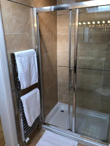 een badkamer met een douche en een glazen deur bij Oakbank - Comfort in the Glens! in Edzell