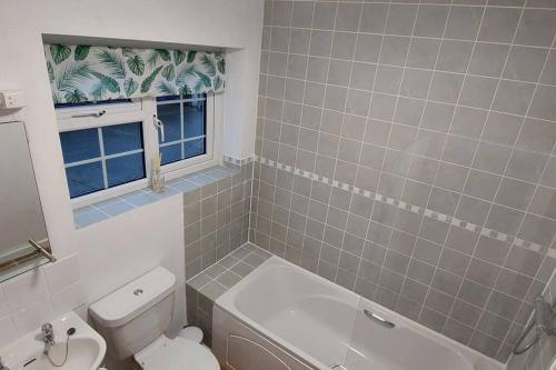een badkamer met een toilet, een bad en een wastafel bij Monks Cleeve Bungalow in Exford