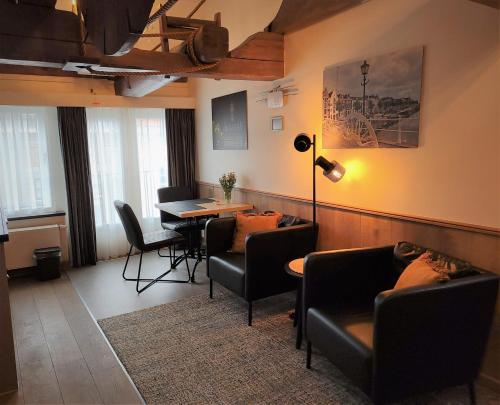 sala de estar con sofás, mesa y sillas en VRYE HEERLYKHEYD ( adults only ) studio 3, en Middelburg