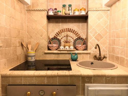 a kitchen with a sink and a counter top at Casetta dello Scrittore in Ostuni