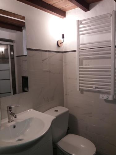 a bathroom with a white toilet and a sink at Casa Daterra in Monsaraz
