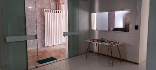 ein Badezimmer mit einem kleinen Tisch und einem Spiegel in der Unterkunft Pousada e Hostel Sossego da Praia AJU in Aracaju