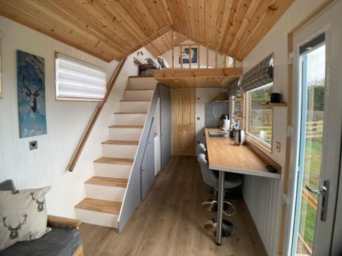 a tiny house with a staircase and a desk at The Ashmere Tiny House in Coldingham