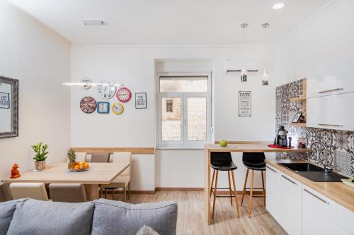 Apartman Nicoletta في سبليت: مطبخ وغرفة معيشة مع أريكة وطاولة