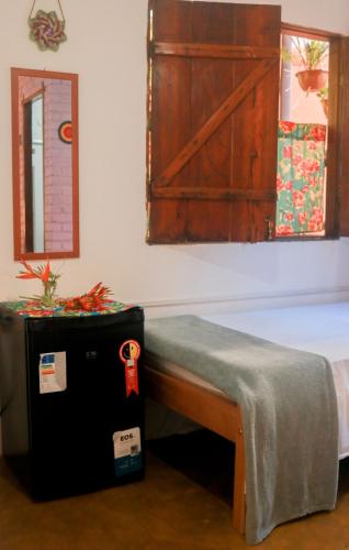a room with a bed with a table and a door at Pousada Guaiamum in Itacaré