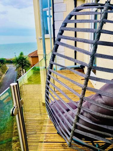 a hammock on a balcony with a view of the ocean at Villa Mentone Hotel in Shanklin
