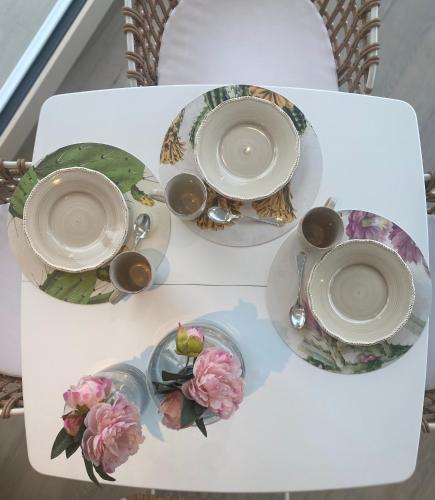 Una mesa con dos tazas y platos y flores encima. en Verdolivo, en Sale Marasino