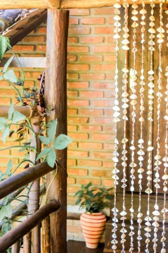 a wooden fence with a plant next to a brick wall at Pousada Guaiamum in Itacaré