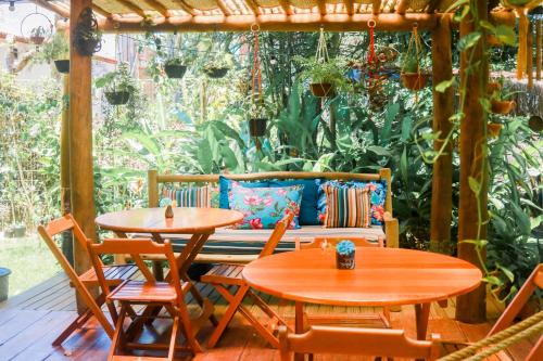 a patio with two tables and a couch at Pousada Guaiamum in Itacaré