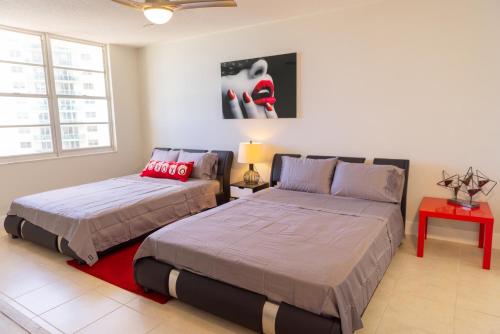 a bedroom with two beds and a red table at Flip Flop Paradise in Hollywood Florida in Hollywood