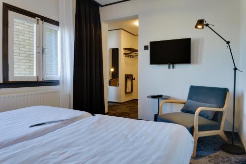 a hotel room with a bed and a television at Hotel Pauw in Nijmegen