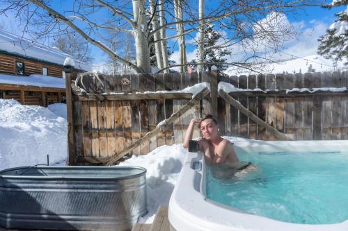 a man in a hot tub in the snow at Beyul Retreat in Meredith