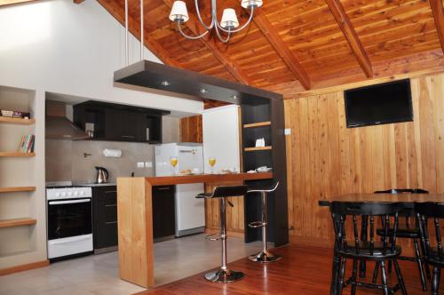 a kitchen with black and white appliances and wooden walls at Monasterio Hotel Boutique in San Carlos de Bariloche
