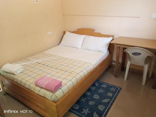a small bedroom with a bed and a desk at Wli Waterfalls Inn in Wli Afegame