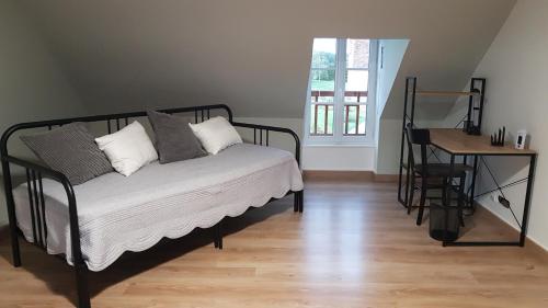 a bed in a room with a table and a window at Les Merisiers in Le Pin-la-Garenne