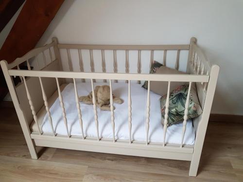 a white crib with a cat laying on it at Les Merisiers in Le Pin-la-Garenne