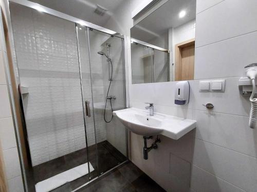 een badkamer met een douche en een wastafel bij Modern studio in the Caesers Garden resort, Swinoujscie in Świnoujście