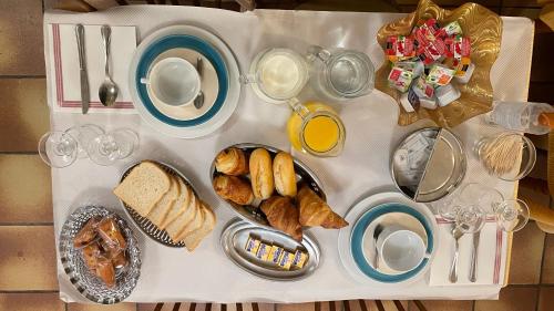 een tafel met ontbijtproducten en drankjes erop bij Hotel CÖRONA Lourdes in Lourdes