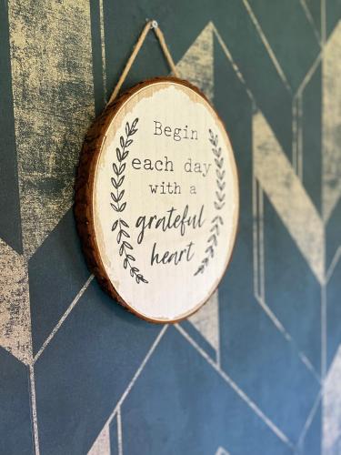 a wooden sign that says begin each day with a grateful heart at Stepping Stones Glamping little red in Bantry
