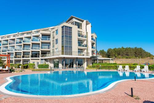 un hotel con piscina frente a un edificio en Menada Sozopol Apartments, en Sozopol