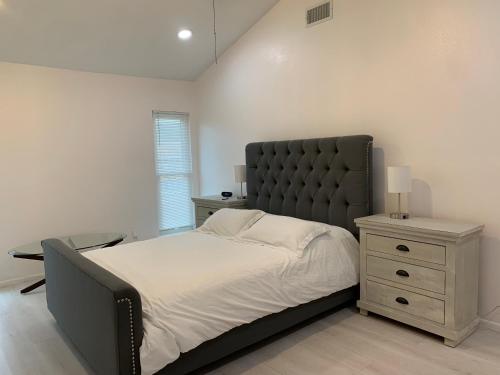 a bedroom with a large bed and a night stand at Cheerful 3-bedroom with a pool in San Antonio