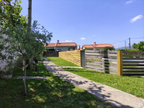 a fence in front of a house with a tree at Casas do Paço - Casas de Férias in Cabeceiras de Basto