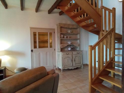 a living room with a staircase and a couch at Les Merisiers in Le Pin-la-Garenne