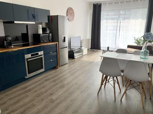 Una cocina y una sala de estar con mesa y sillas. en Le Myanmar - Hyper Centre - Parking - 4p, en Le Mans