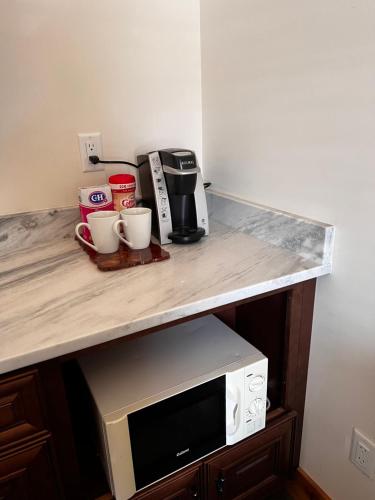 a counter top with a coffee maker and a microwave at Enchantment Lodges - 5 min walk to downtown in Leavenworth