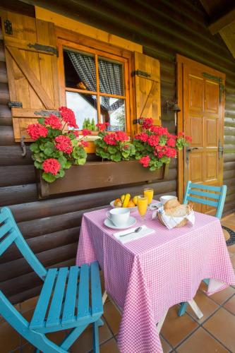 a table with a pink table cloth and two chairs and flowers at Cabañas de Lires in Lires