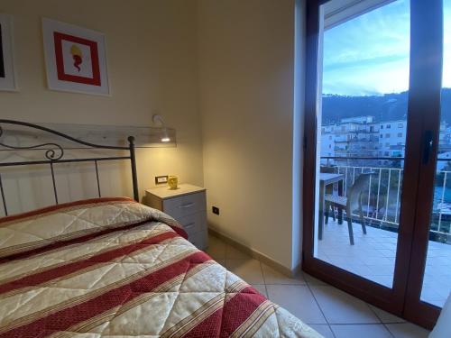 a bedroom with a bed and a view of a balcony at The Reef Apartment in Sorrento