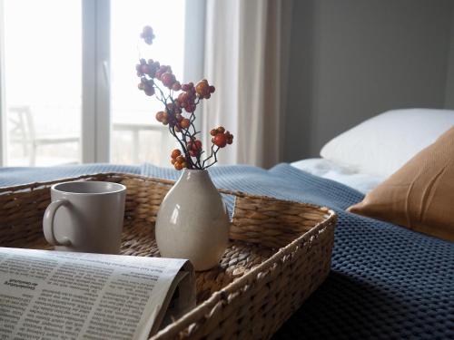 einen Tisch mit einem Buch und eine Vase mit Blumen darin in der Unterkunft Wohlfühl-Apartment am Lösnitzgrund in Radebeul