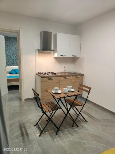 a kitchen with a table and two chairs and a counter at Bed Nonnonino in Porto Cesareo