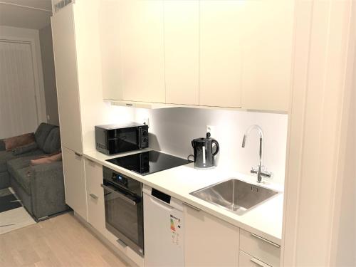 a small kitchen with a sink and a microwave at Scandpoint Apartments OSLO ski in ski out all year in SNOOSLO with Free Parking in Høybråten