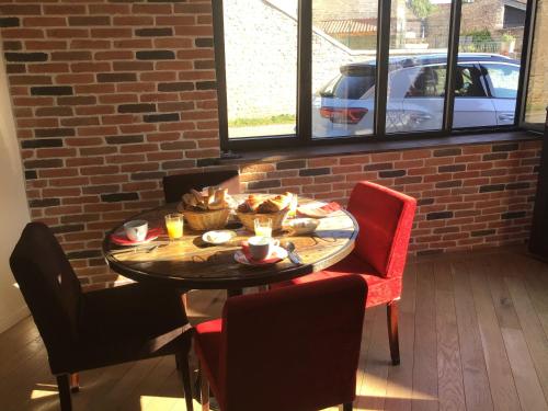 a table with food on it in a room with a brick wall at L'Atelier 1 in Corcelles-les-Arts