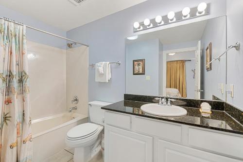 a white bathroom with a sink and a toilet at Calypso Resort Beachfront Condo in Panama City Beach