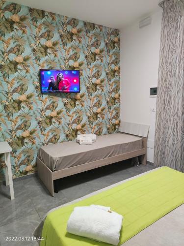 a room with a bed and a tv on a wall at Bed Nonnonino in Porto Cesareo