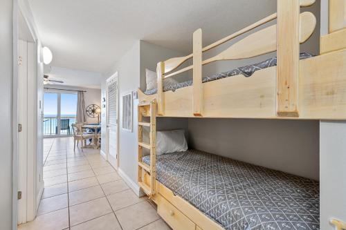 a bedroom with bunk beds and a dining room at Calypso Resort Beachfront Condo in Panama City Beach