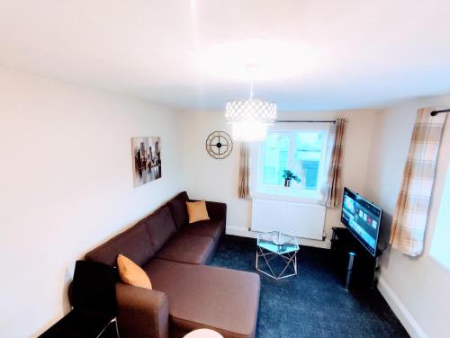 a living room with a couch and a tv at Crystal Suite 2 -free private parking in North Shields