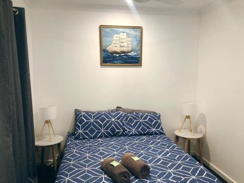 Shark Bay Cottages في دينهام: غرفة نوم مع سرير مع دبتين عليه