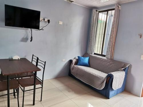 a living room with a couch and a table at Apartamento con dos habitaciones in San Isidro de El General