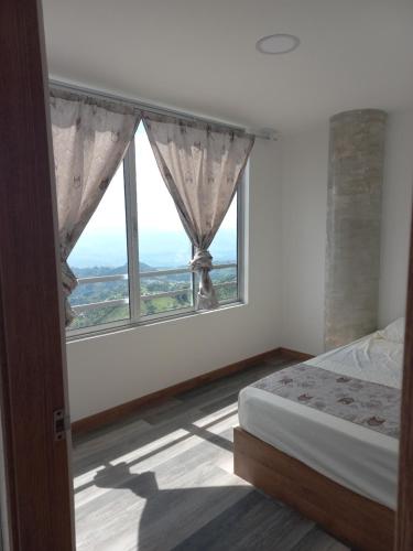 una camera con un letto e una grande finestra di Apartamento FL Martinz a Manizales