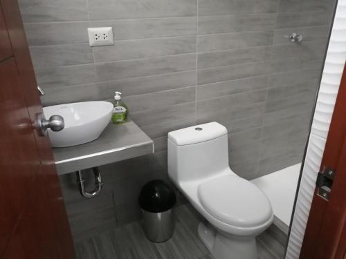 uma casa de banho com um WC branco e um lavatório. em Apartamento familiar em Tarapoto