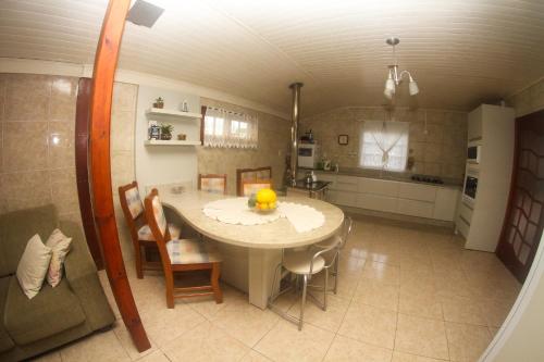 a kitchen and dining room with a table and chairs at Rosa dos Ventos - CASA in Urubici